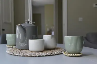 a table with green and white cups and a kettle at Old Green Chambers spacious town centre apartment with free parking! in St Ives