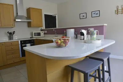 a kitchen with a counter with a bowl of fruit on it at Old Green Chambers spacious town centre apartment with free parking! in St Ives