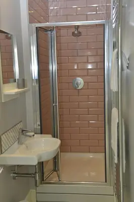a bathroom with a sink and a shower at Old Green Chambers spacious town centre apartment with free parking! in St Ives