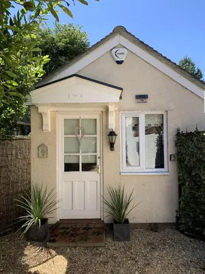a house with a white door and two plants at Thorn House in Fen Drayton