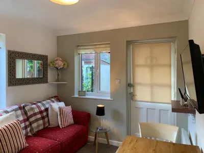 a living room with a red couch and a table at Thorn House in Fen Drayton