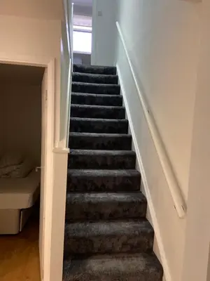 a staircase leading up to a room with a bed at Corporate Large Modern 4 to 5 Bedroom House in Bishops Stortford