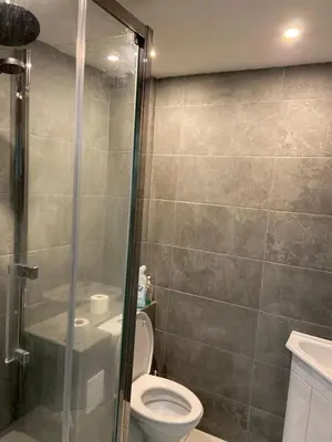 a bathroom with a toilet and a glass shower at Corporate Large Modern 4 to 5 Bedroom House in Bishops Stortford