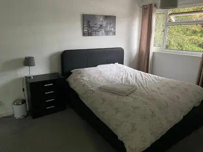 a bedroom with a bed and a dresser and a window at Corporate Large Modern 4 to 5 Bedroom House in Bishops Stortford