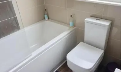 a bathroom with a white toilet and a tub and a toilet at Corporate Large Modern 4 to 5 Bedroom House in Bishops Stortford