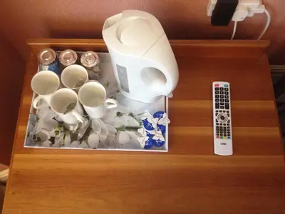 a wooden drawer with a remote control and cups at Welbeck Hotel - Close to Beach, Train Station & Southend Airport in Southend-on-Sea