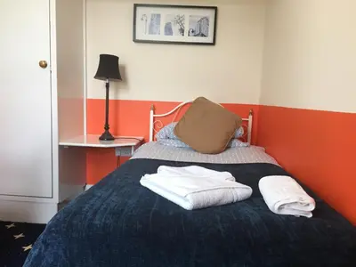 a bedroom with a bed with two towels on it at Welbeck Hotel - Close to Beach, Train Station & Southend Airport in Southend-on-Sea