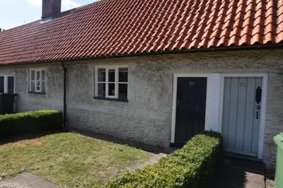 a small brick house with a red roof at The Alms House in Thetford