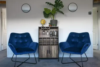 two blue chairs in a room with a plant at Niche Sunrise Townhouse in Chelmsford