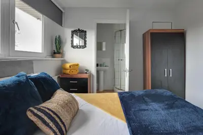a living room with a bed and a bathroom at Niche Sunrise Townhouse in Chelmsford
