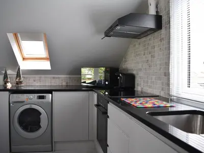 a kitchen with a washing machine and a sink at Rainbows End in Saint Lawrence