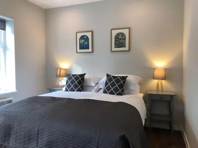 a bedroom with a large bed with two lamps at Church View Bungay in Bungay
