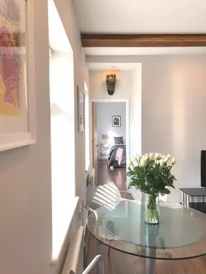 a living room with a glass table with a vase of flowers at Church View Bungay in Bungay