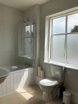 a bathroom with a toilet and a sink and a window at Church View Bungay in Bungay