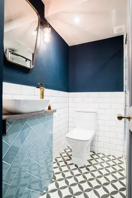 a bathroom with a toilet and a blue wall at The Lodge Duxford in Duxford