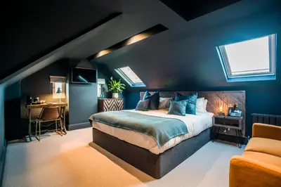 a bedroom with blue walls and a bed and a desk at The Lodge Duxford in Duxford