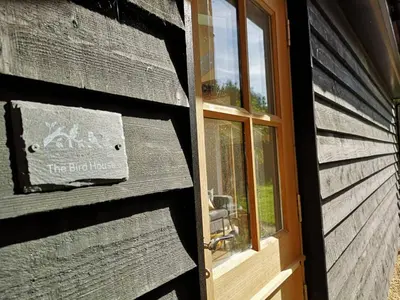 a door to a building with a sign on it at The Bird House at Woodburn Cottage in Dedham