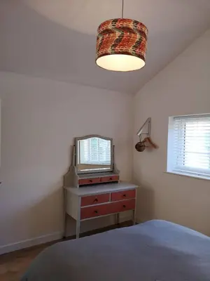 a bedroom with a bed and a tv on a dresser at The Bird House at Woodburn Cottage in Dedham