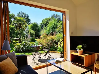 a living room with a couch and a large window at The Bird House at Woodburn Cottage in Dedham
