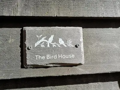 a sign for the bird house on the side of a building at The Bird House at Woodburn Cottage in Dedham
