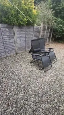 a black chair sitting in a yard at Homely & Cosy 3 Bed Birch Close House with Free Parking, Garden & Sleeps 8 in Cambridge