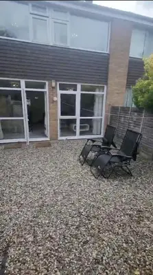 two chairs sitting in front of a house at Homely & Cosy 3 Bed Birch Close House with Free Parking, Garden & Sleeps 8 in Cambridge