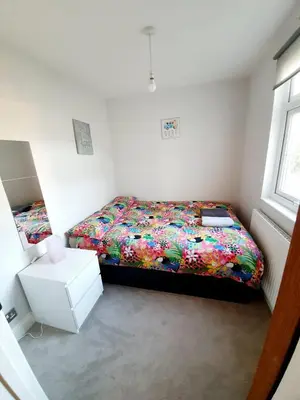 a small bedroom with a bed with a colorful comforter at Beautiful 3 Bedroom House at the Sea Front - Amazing Location in Southend-on-Sea