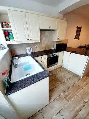 a kitchen with white cabinets and a sink at Beautiful 3 Bedroom House at the Sea Front - Amazing Location in Southend-on-Sea