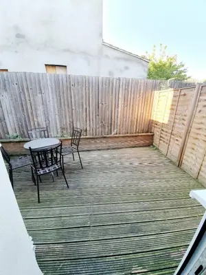 a patio with a table and chairs and a fence at Beautiful 3 Bedroom House at the Sea Front - Amazing Location in Southend-on-Sea