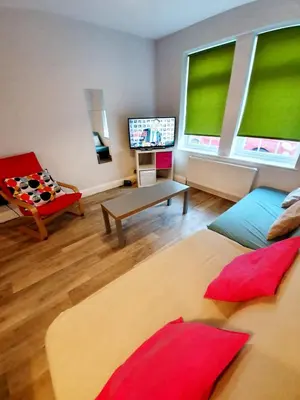 a living room with a couch and a television in it at Beautiful 3 Bedroom House at the Sea Front - Amazing Location in Southend-on-Sea