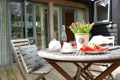 a wooden table with a plate of food and flowers at Yew Tree Farm Stable, Worlingworth in Worlingworth