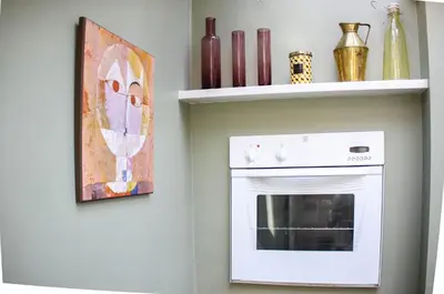 a kitchen with a white oven and a painting on the wall at Bloom Cottage in Aldeburgh