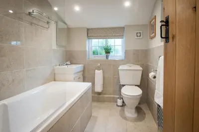 a bathroom with a tub and a toilet and a sink at Westgate Lodge at Dedham in Dedham