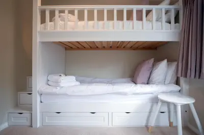 a white bunk bed with towels and a stool at Westgate Lodge at Dedham in Dedham