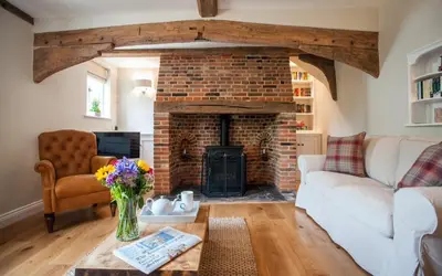 a living room with a brick fireplace and a white couch at Westgate Lodge at Dedham in Dedham