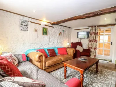 a living room with two couches and a table at Garden House in Thetford