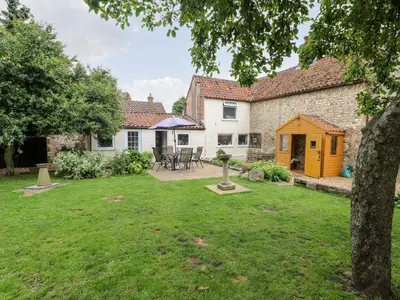 a view of the garden of a cottage with a yard at Garden House in Thetford