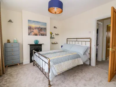 a bedroom with a bed and a blue lamp at Sea View Cottage in Frinton-on-Sea