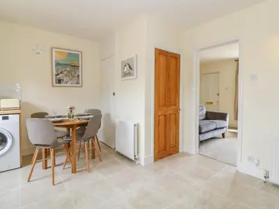 a kitchen and dining room with a table and chairs at Sea View Cottage in Frinton-on-Sea
