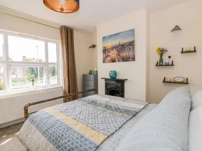 a bedroom with a bed and a window at Sea View Cottage in Frinton-on-Sea