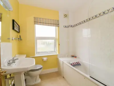 a bathroom with a sink and a toilet and a tub at Sea View Cottage in Frinton-on-Sea