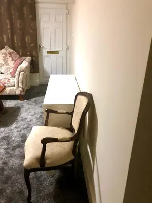a room with a chair and a table and a door at AC Lounge 115 in Rochford