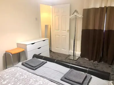 a bedroom with a bed and a dresser and a closet at AC Lounge 115 in Rochford