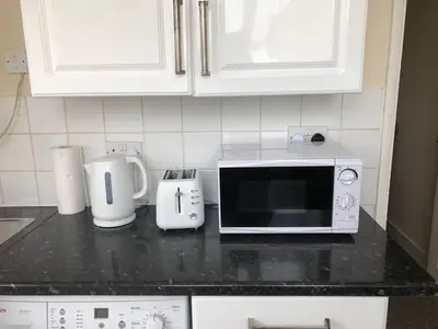 a kitchen counter with a microwave and appliances on it at AC Lounge 115 in Rochford