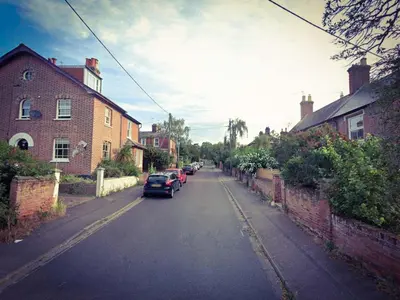 a street with cars parked on the side of the road at Cosy Cottage Fireplace Patio Pet Train Stn in Wivenhoe