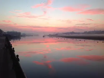 a large body of water with pink clouds in the sky at Cosy Cottage Fireplace Patio Pet Train Stn in Wivenhoe