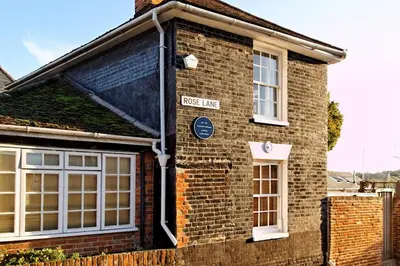 a brick house with a sign on the side of it at Cosy Cottage Fireplace Patio Pet Train Stn in Wivenhoe