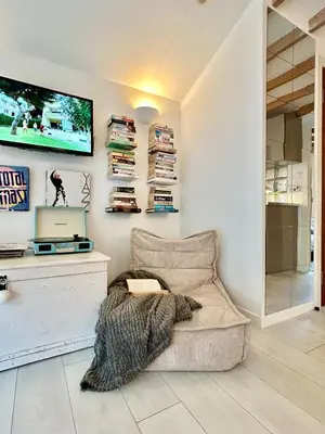 a living room with a couch and a laptop on a wall at Modern self contained tiny home with patio in Loughton