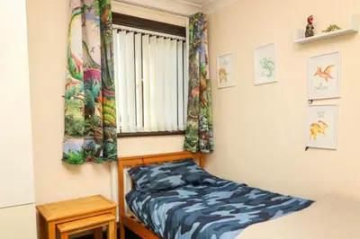a bedroom with a bed and a window with curtains at Pet Friendly Home in Chelmsford-Hot Tub-Sleeps 6 in Latchingdon and Snoreham