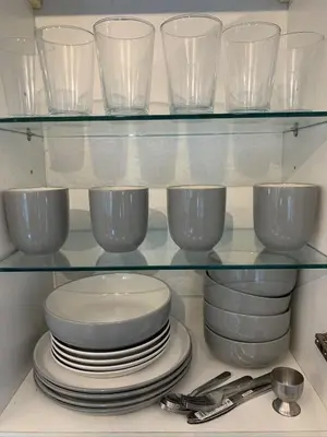 a glass shelf with plates and bowls on it at Myrtle cottage in Dickleburgh